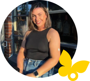 Woman standing by a building wearing a FreeStyle Libre 2 Plus sensor