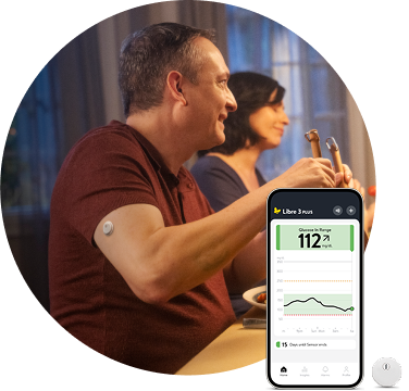 Man wearing a FreeStyle Libre 3 Plus sensor at the dinner table, overlaid with an image of the sensor and a smartphone displaying the Libre app