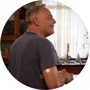 Smiling man in the kitchen wearing a FreeStyle Libre 3 Plus sensor