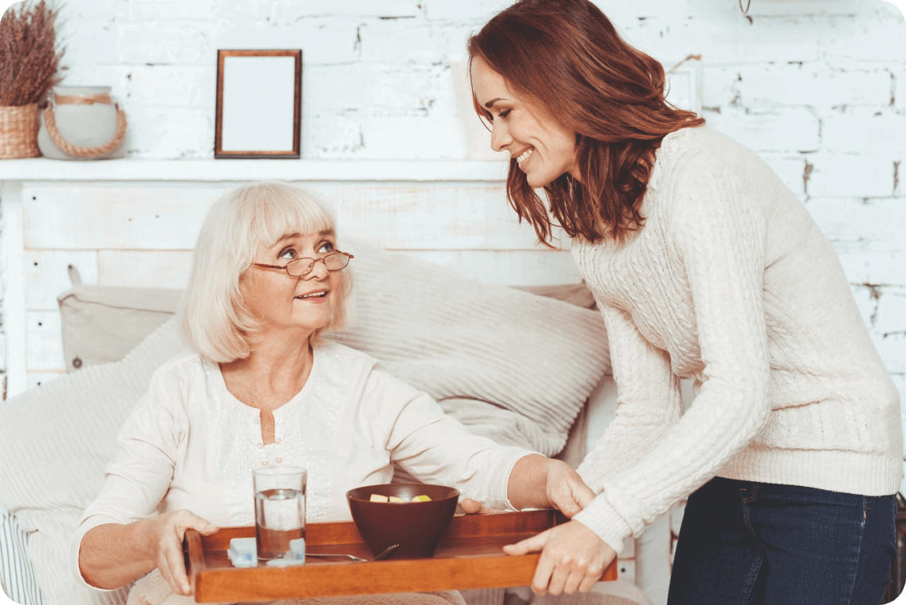 A elderly woman gitting food from  younger woman