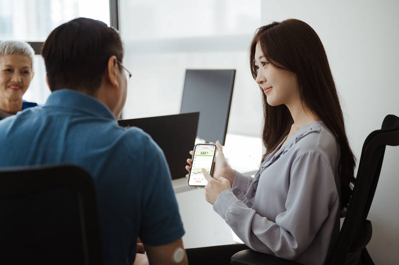 Ασθενής με αισθητήρα βλέπει μαζί με την κόρη του την εφαρμογή LibreLinkUp στο κινητό της