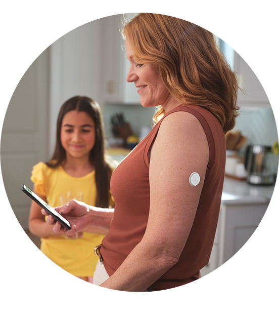 Woman standing in kitchen with sensor visible on the back of her upper arm
