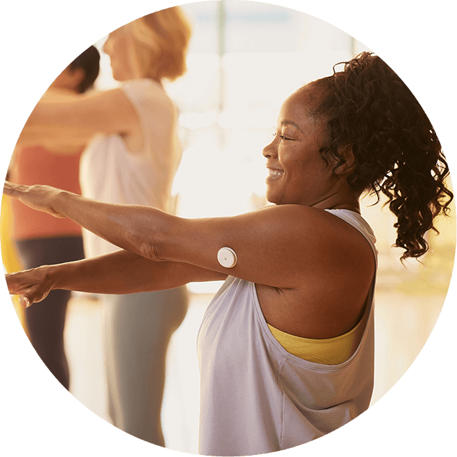 Woman wearing FreeStyle Libre 2 sensor looking at her mobile device