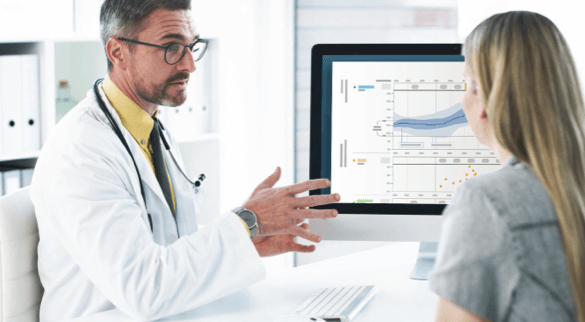 HCP explaining to a patient and pointing at a computer