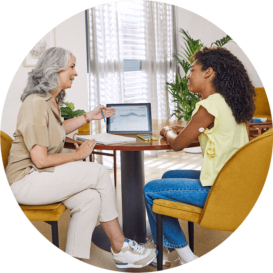HCP talking with patient with a sensor on her upper arm