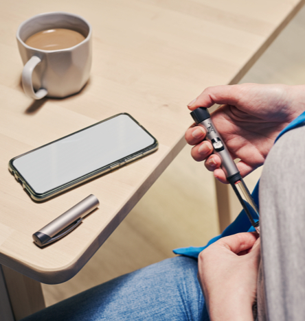 NovoPen user sitting down and using her NovoPen insulin pen.