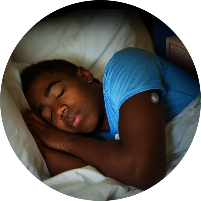 A child sleeping with FreeStyle Libre sensor visible on the back of his upper arm