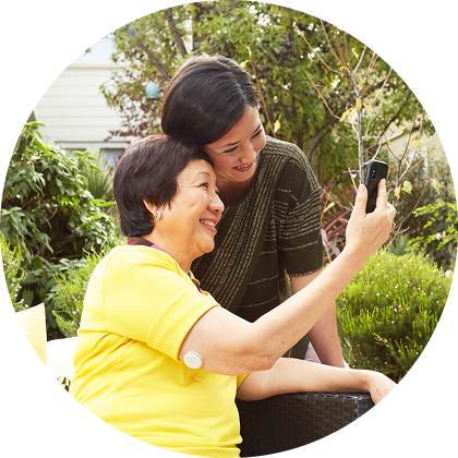 Un proche aidant et une personne portant un capteur FreeStyle Libre consultent les mesures sur un smartphone ou un lecteur