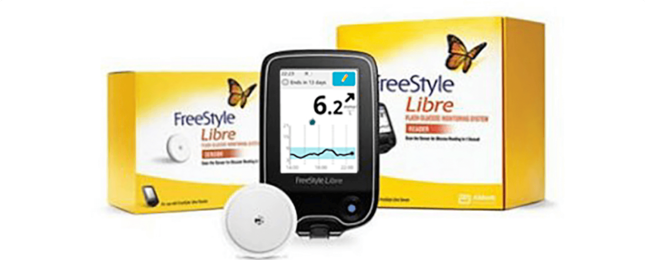 A Freestyle Libre sensor and reader in front of two system kit boxes