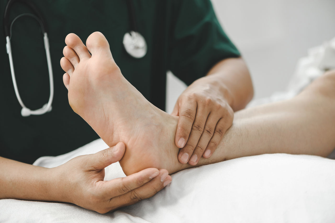 Consultation physiotherapist with the treatment of treating injured ankle pain in modern clinics.Concept of physical rehabilitation.