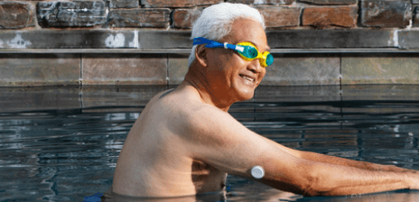 A man wearing a glucose sensor goes for a swim.