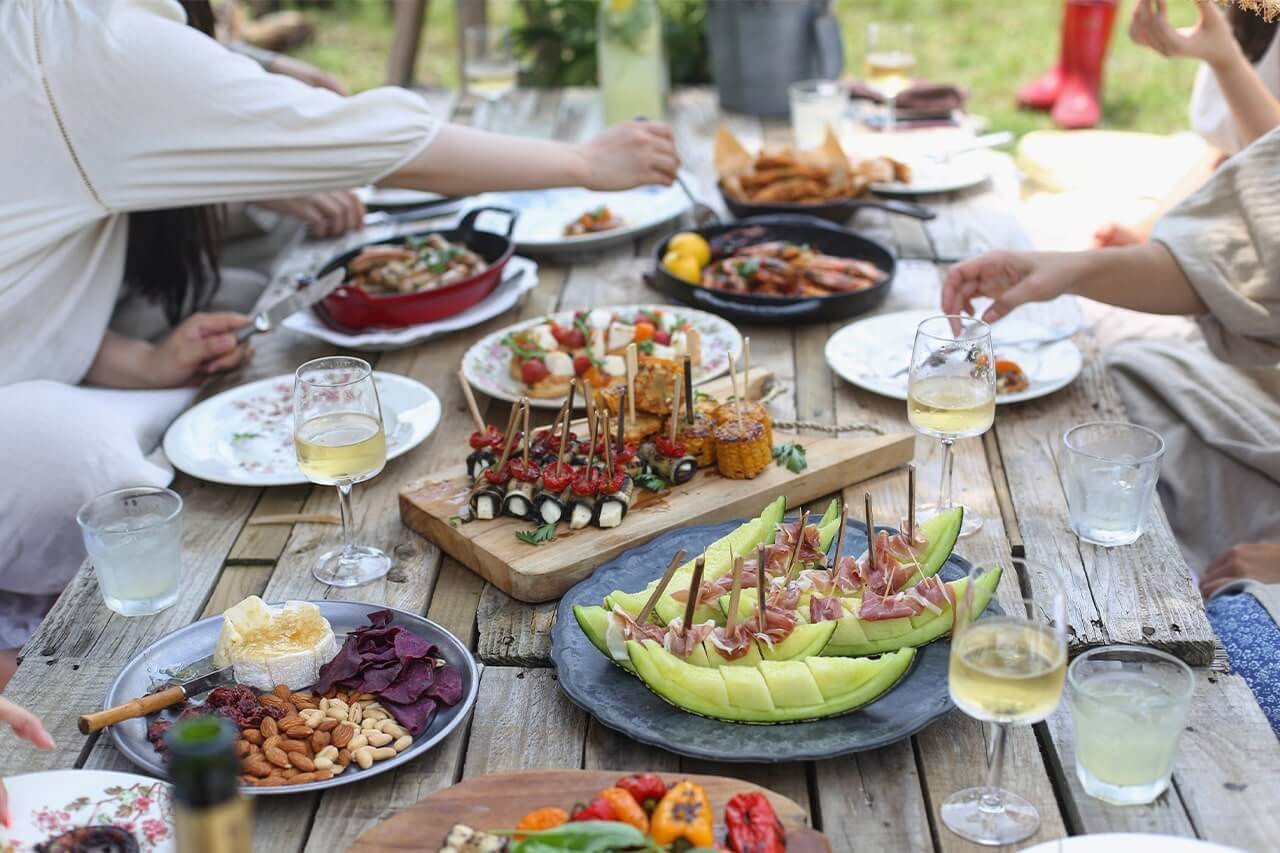 Mesa com vários pratos com comida e copos