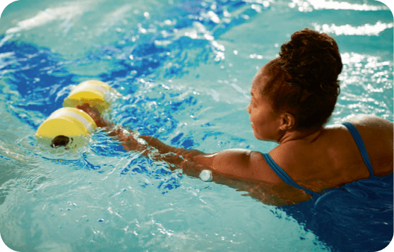 A woman swiming in the pool with FreeStyle Libre Sensor visible on the back of her upper arm