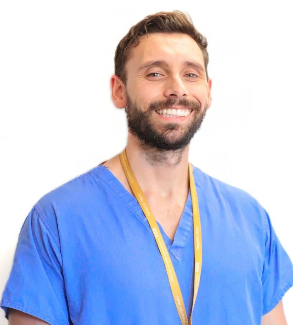 Mark, blog author, smiling in blue medical scrubs
