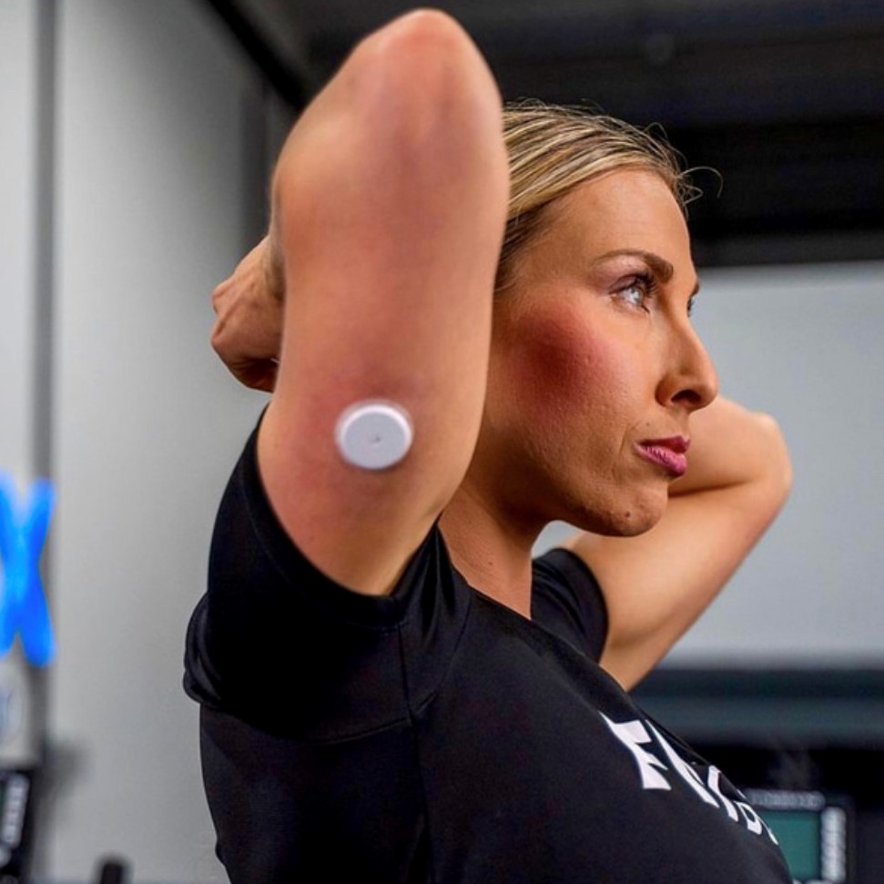 A women doing sport while a visible FSL sensor shown applied on the back of her upper arm.