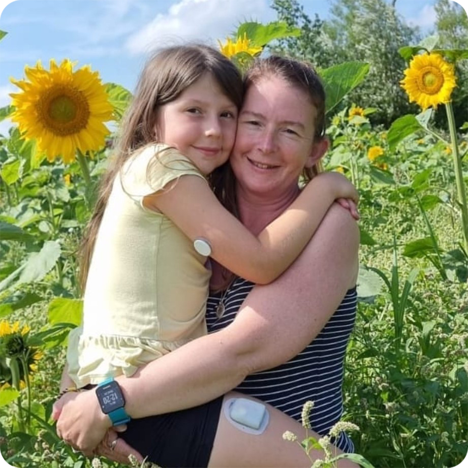 A mother and her daughter standing in a field of sunflowers