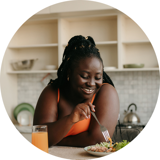 a woman eating her food and wearing a Libre 3 Plus sensor