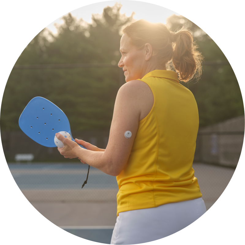 an image of a woman playing pickleball with a visible sensor on her arm