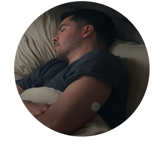 Man sleeping in bed with a sensor on his upper arm