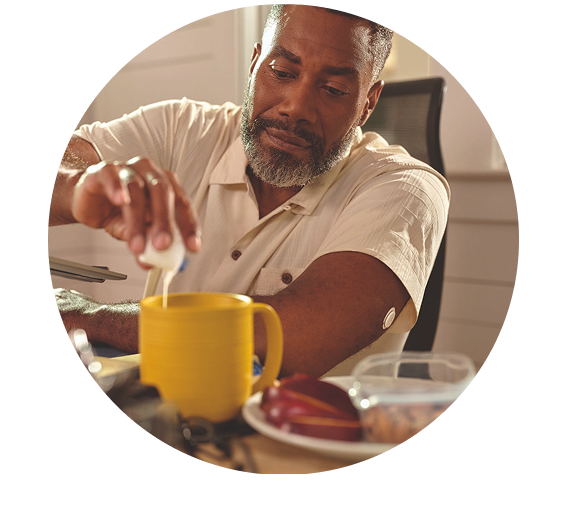 a man is adding milk to his drink and a freestyle libre sensor is visible on his arm