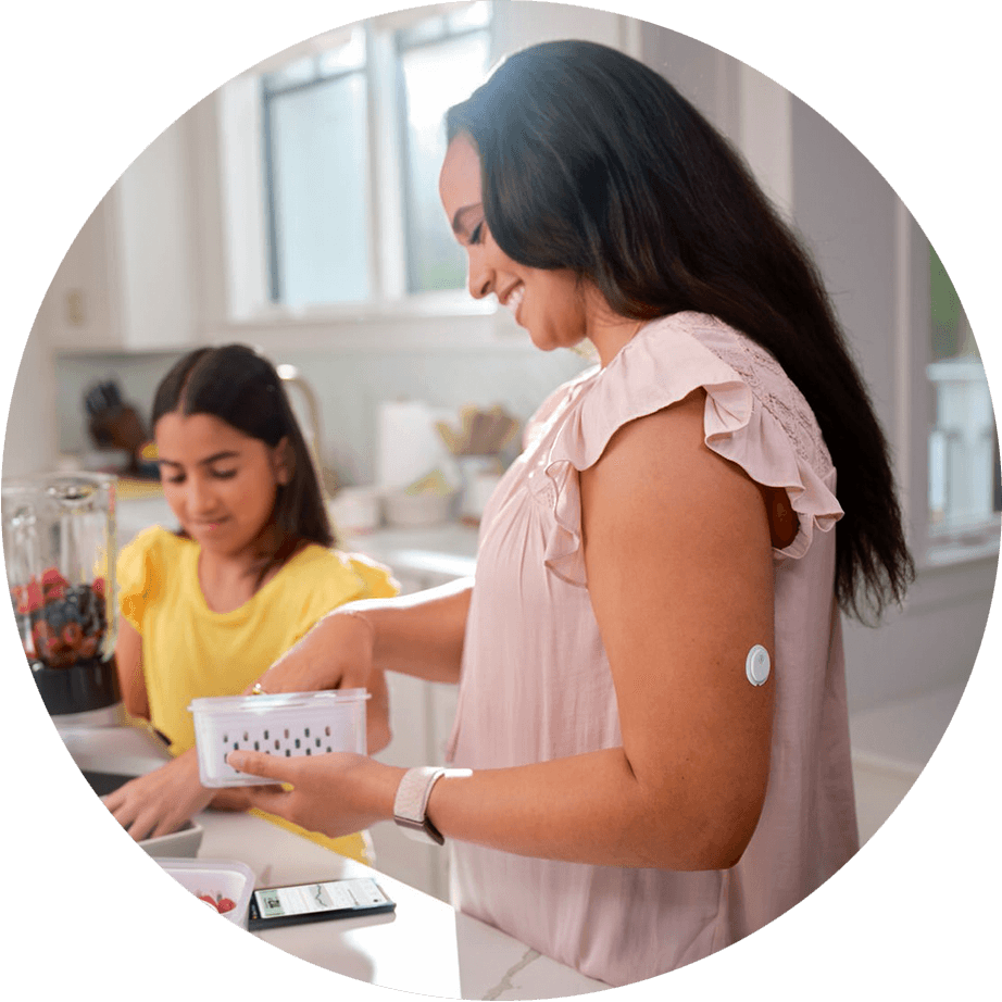 Mother wearing Libre 3 sensor and child in the kitchen