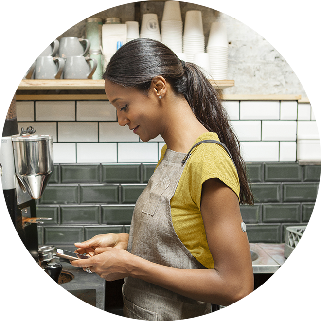 Woman with Libre 2 Plus sensor and looking at her smartphone
