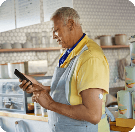 Women using the FreeStyle Libre app while having the FreeStyle Libre applied on her arm.
